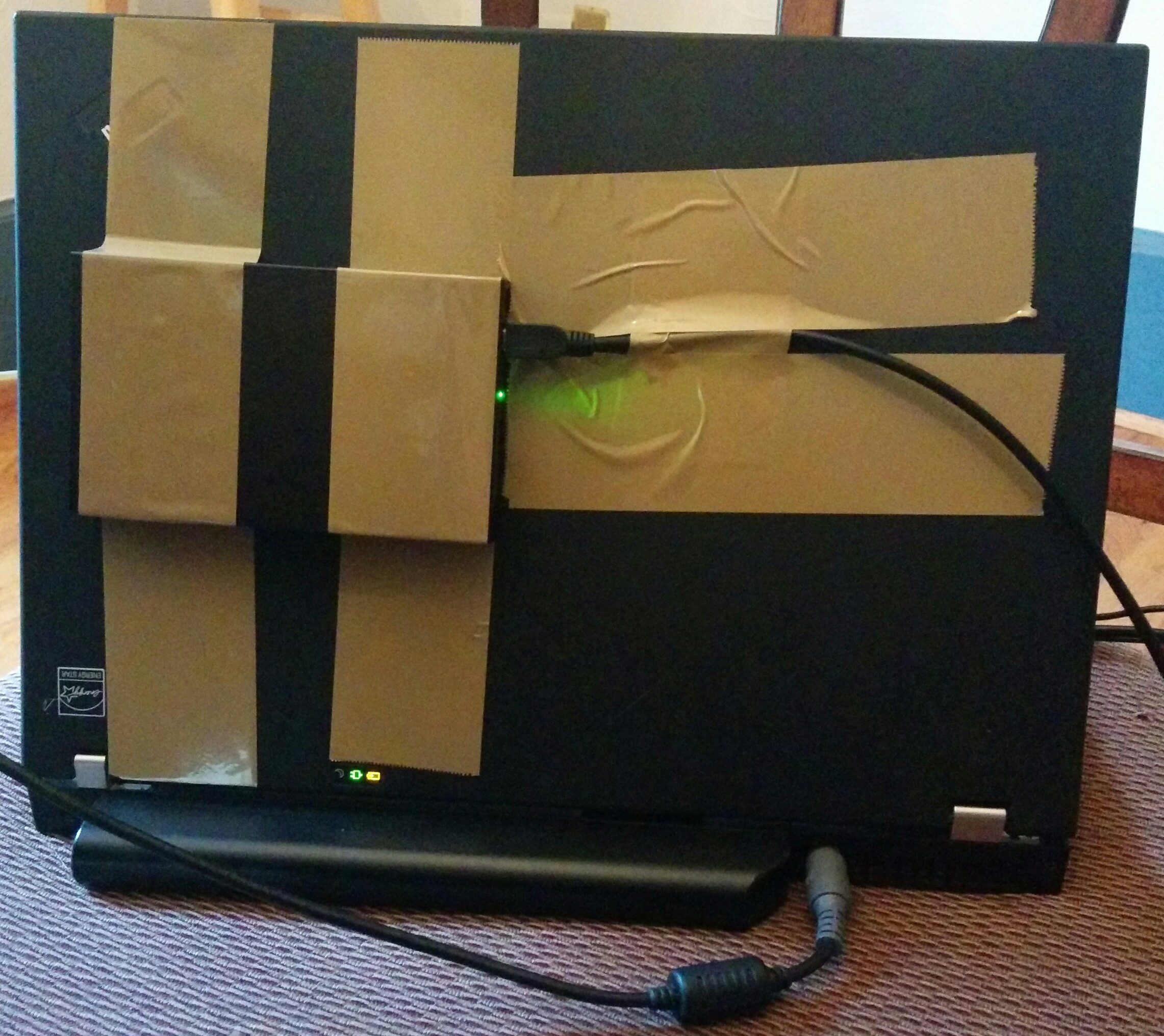 A ThinkPad laptop held together with packing tape